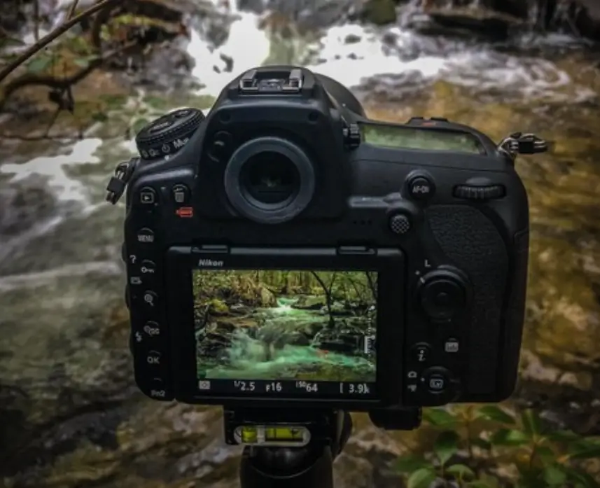 Camera capturing a waterfall scene on display.